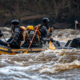 a group of rafters assessing the rapids ahead, checking their surroundings before embarking on the adventure.