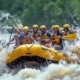 a dynamic scene captures a vibrant group of adventurous rafters navigating through roaring whitewater rapids in tennessee, with towering rock formations and an intense cascade of water splashing around them, highlighting the thrill of an unforgettable overnight rafting trip.