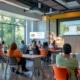 a vibrant, educational session on eco-friendly rafting takes place in a modern, indoor conference room, where enthusiastic rafters engage with interactive displays highlighting ocoee river conservation efforts.